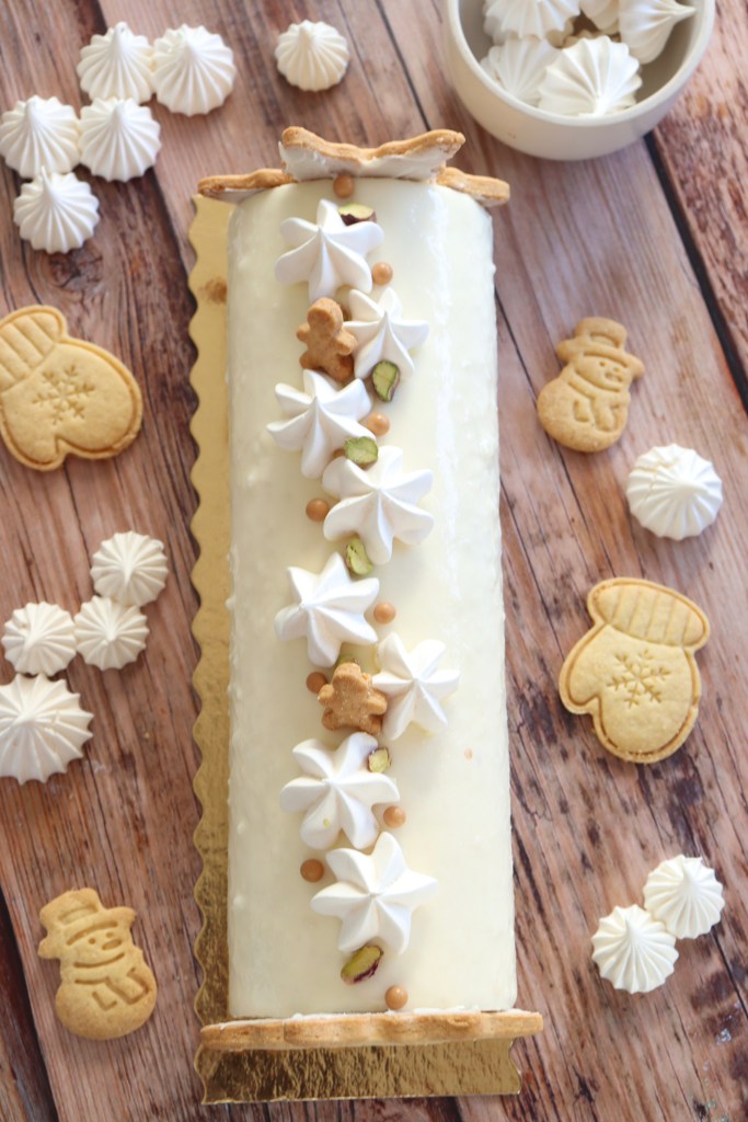 Bûche roulée à la vanille et à la framboise recouverte de meringue et de pistache, accompagnée de sablés de Noel 