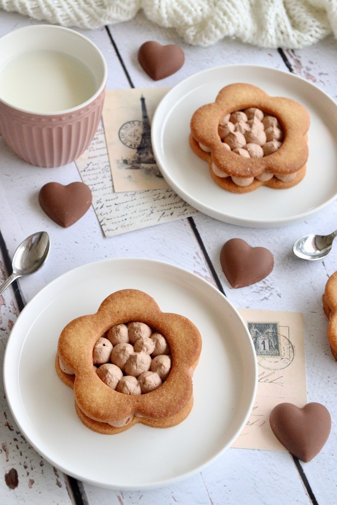 Tartes à la ganache au chocolat au lait en forme de fleur sur une assiette blanche avec un verre de lait et des chocolats en forme de coeur