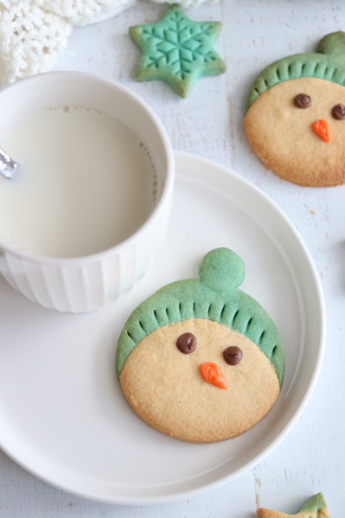sablés de noël en forme de bonhomme de neige sur une assiette blanche