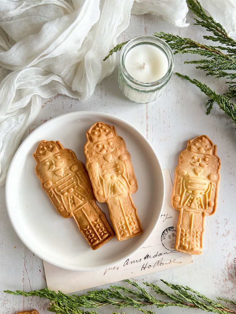 sablés de Noël en forme de casse noisette sur une assiette blanche
